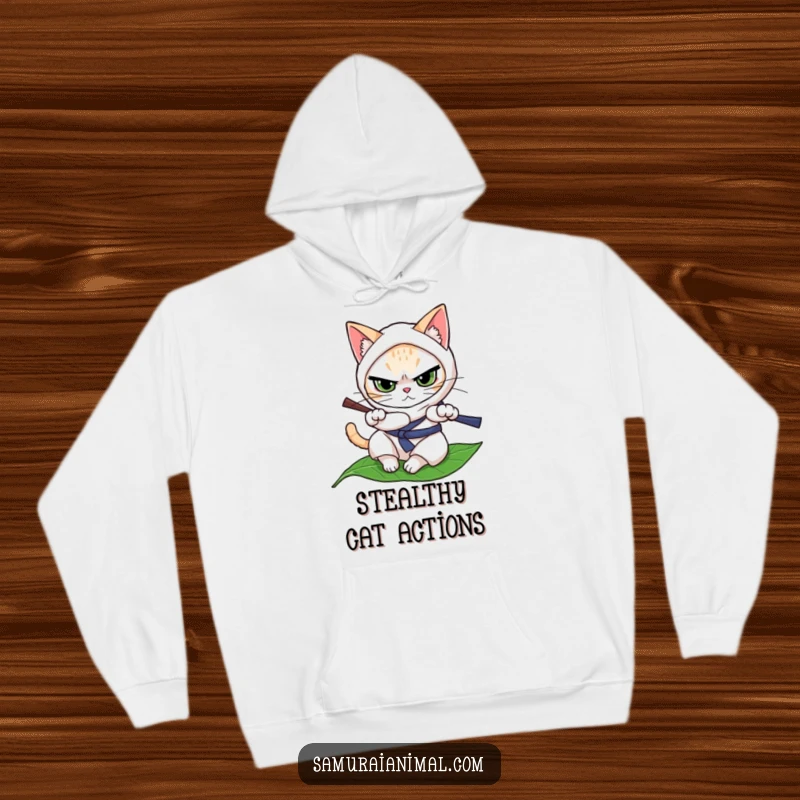 Funny cat in a ninja pose, determinedly rolling on a leaf for a cozy and humorous hoodie.