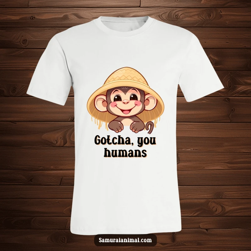 Funny t-shirt showing a nimble monkey character grinning mischievously while peeking out from behind a straw hat.